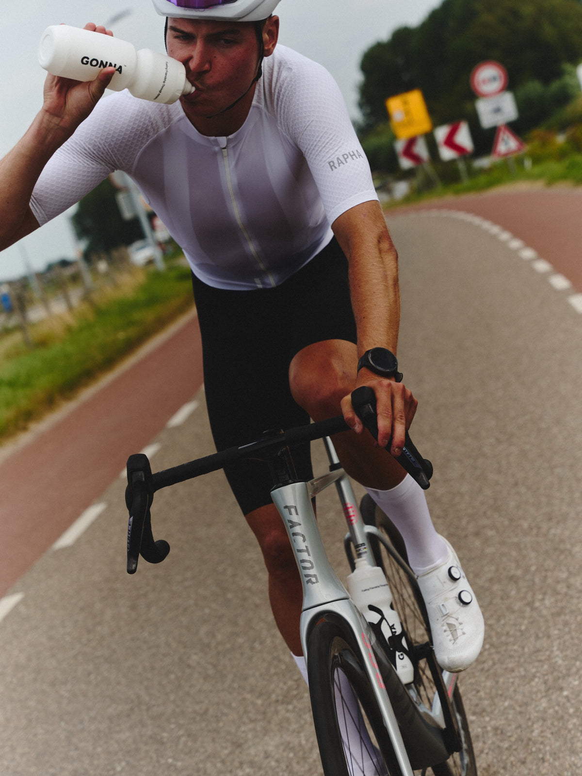 Cyclist drinking GONNA carb and electrolyte drink mix while riding